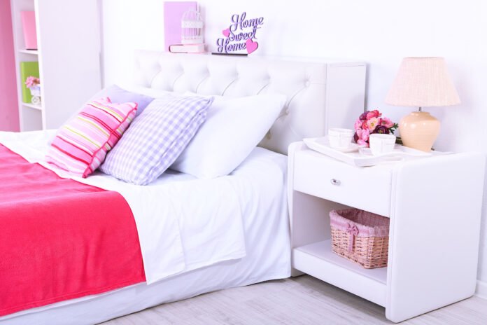 Cozy bedroom with colorful pillows and lamp.